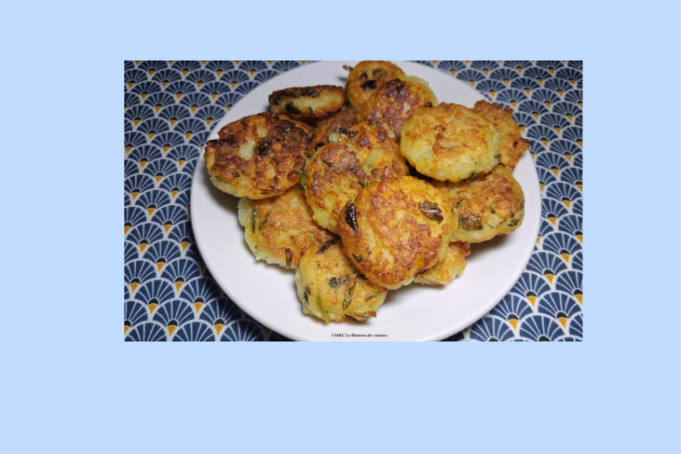 Assiette blanche garnie de galettes dorées et croustillantes, parsemées d’herbes, posée sur une nappe colorée à motifs sur fond bleu clair avec divers épices et pomme de terre