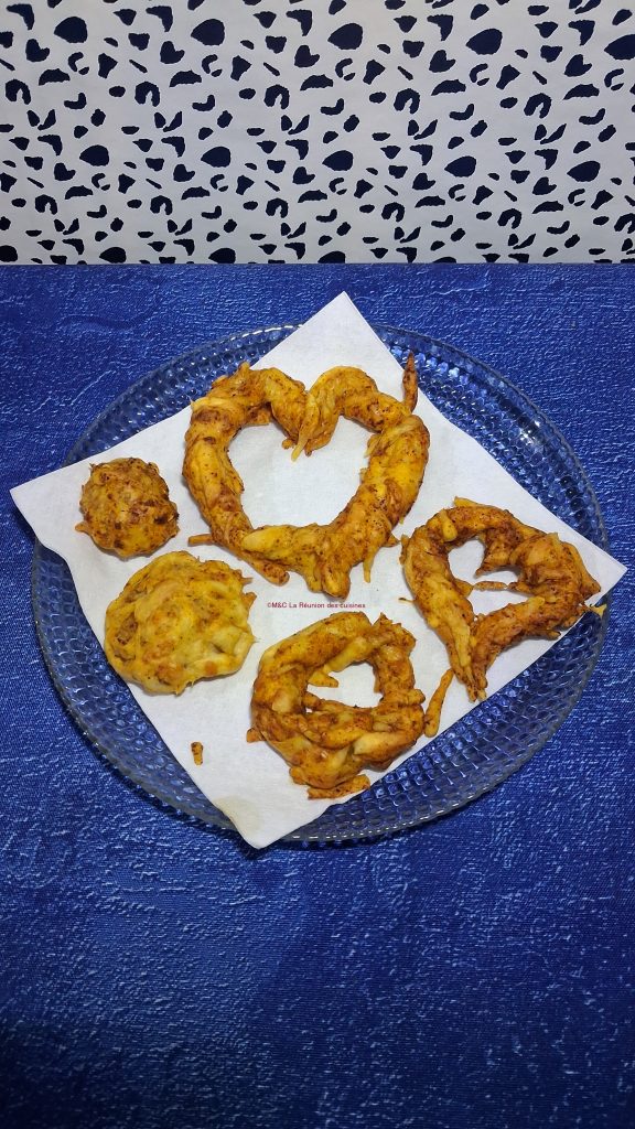 Chutes de pâte feuilletée antigaspi façonnées en cœurs et en boules, dorées au fromage et au paprika doux, présentées dans une assiette en verre.