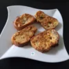 Gros plan sur quatre tranches de pain de boulanger enrobées d'œuf et de basilic, parfaitement dorées