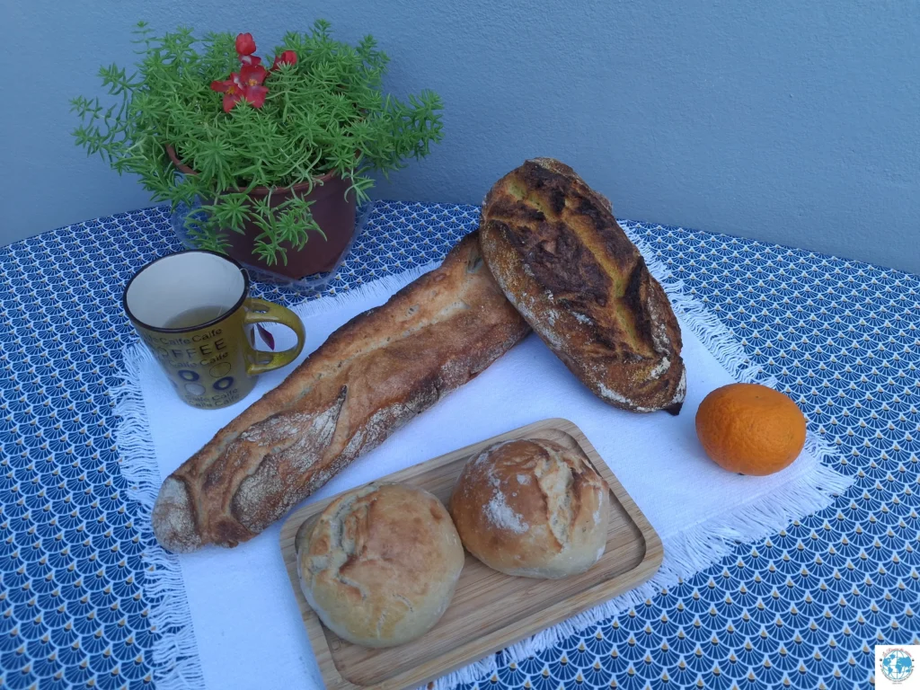 Assortiment de pains variés sur une table, avec thé et décor, pour illustrer un Zoom sur le pain.