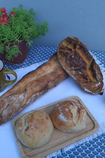 Assortiment de pains variés sur une table, avec thé et décor, pour illustrer un Zoom sur le pain.