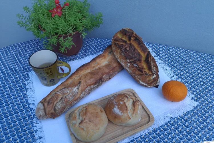 Assortiment de pains variés sur une table, avec thé et décor, pour illustrer un Zoom sur le pain.