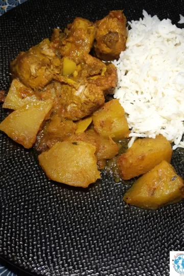 Une assiette noire texturée présentée avec un carry porc chouchou, plat traditionnel de La Réunion. En bas, à droite est visible le logo "La Réunion des cuisines"